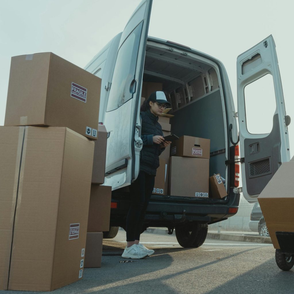 Two couriers load boxes into a van for shipment, showcasing logistics and teamwork.