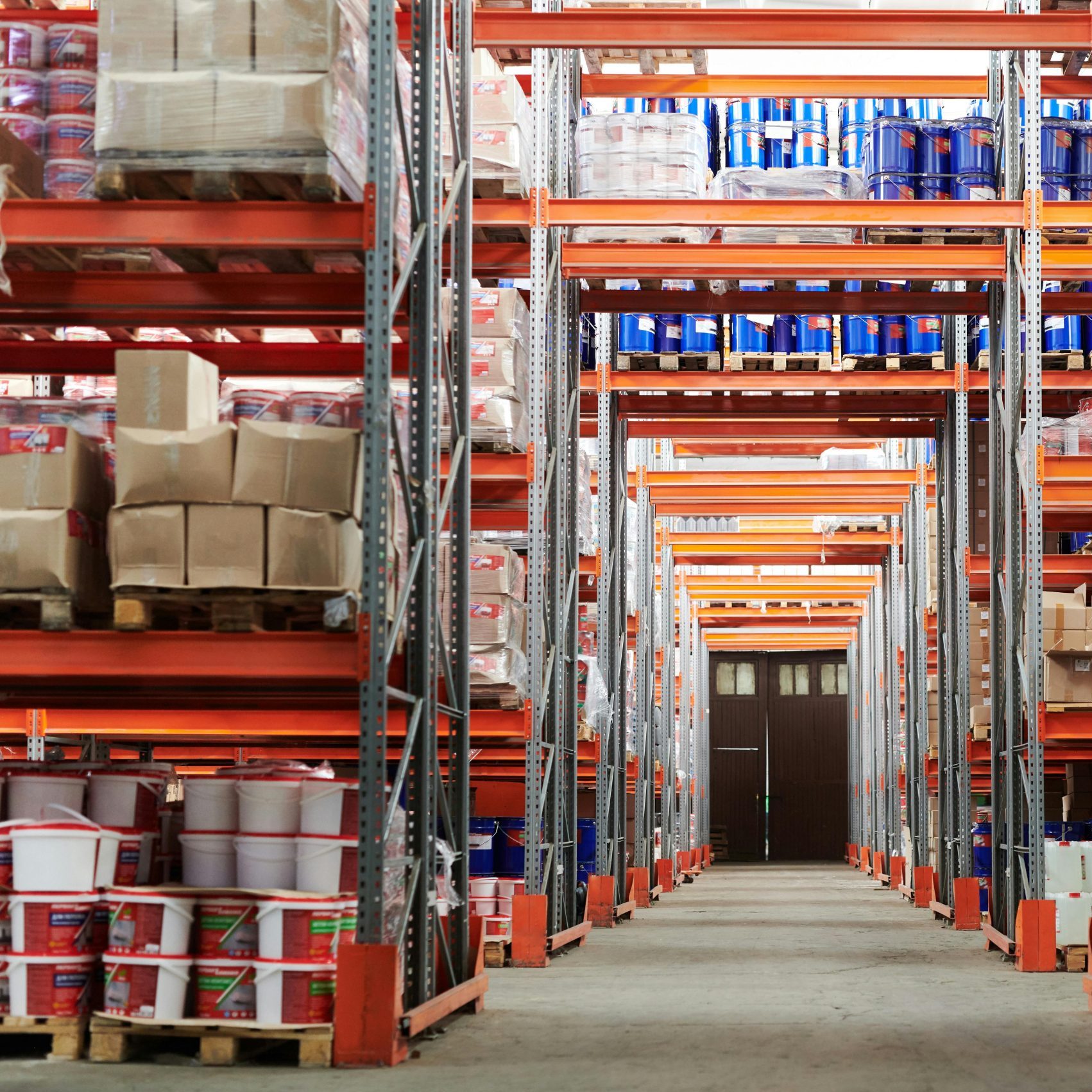 Wide angle view of a warehouse with stocked shelves and boxes.